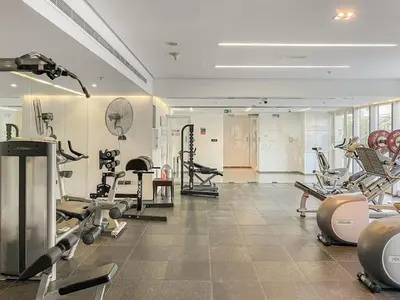a gym with a lot of equipment in a room at FIRST CLASS 1BR Luxury Meets Simplicity in Dubai