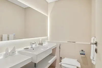 a white bathroom with a sink and a toilet at FIRST CLASS 1BR Luxury Meets Simplicity in Dubai