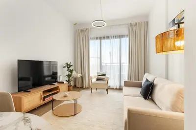 a living room with a couch and a tv at FIRST CLASS 1BR Modern with Tranquil Touch in Dubai