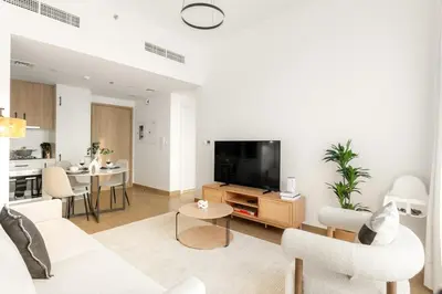 a living room with a couch and a tv at FIRST CLASS 1BR Modern with Tranquil Touch in Dubai