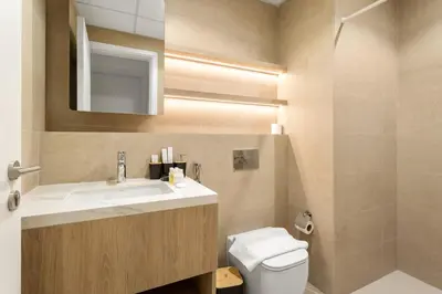 a bathroom with a sink and a toilet and a mirror at FIRST CLASS 1BR Modern with Tranquil Touch in Dubai
