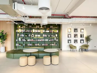 a lobby with two tables and a book shelf at FIRST CLASS 1BR Modern with Tranquil Touch in Dubai