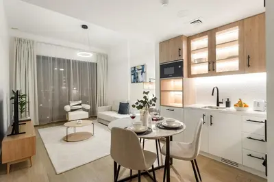 a kitchen and living room with a table and chairs at FIRST CLASS 1BR Modern with Tranquil Touch in Dubai