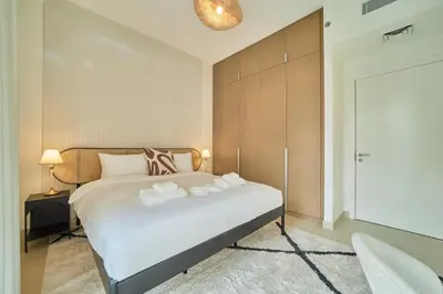 a bedroom with a bed with two towels on it at Chic & Sunny 1BR Escape At Grove Creek Beach Access in Dubai