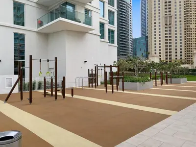 a park with a bunch of playground equipment in a city at FIRST CLASS 1BR Stylish Beachfront Escape in Dubai