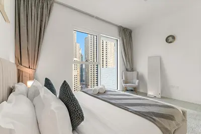 a bedroom with a large bed with a large window at FIRST CLASS 1BR Stylish Beachfront Escape in Dubai