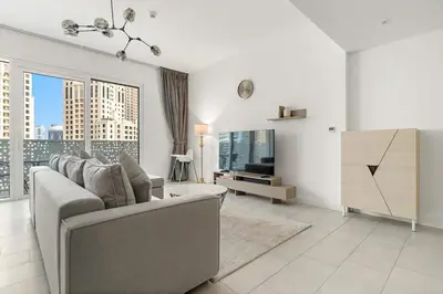 a living room with a couch and a large window at FIRST CLASS 1BR Stylish Beachfront Escape in Dubai