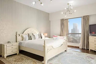 a bedroom with a white bed and a large window at FIRST CLASS 3BR Sea View Near JBR Beach in Dubai