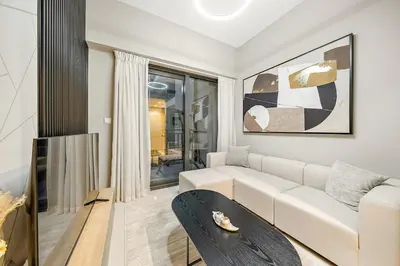 a living room with a white couch and a table at FIRST CLASS 1BR Modern Serenity in Dubai