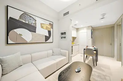 a living room with a white couch and a table at FIRST CLASS 1BR Modern Serenity in Dubai