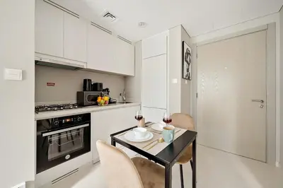 a kitchen with a table with two chairs and a stove at FIRST CLASS 1BR Modern Serenity in Dubai