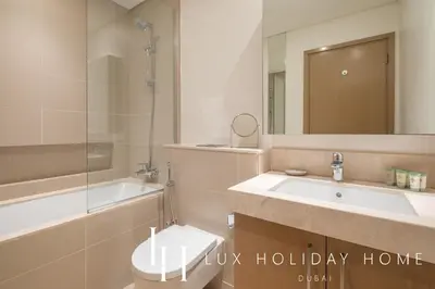 a bathroom with a sink and a toilet and a mirror at LUX 52 42 Deluxe Marina View Suite 3 in Dubai