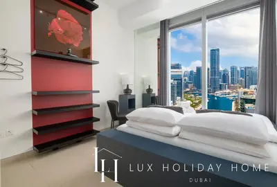 a bedroom with a bed with a view of the city at LUX 52 42 Deluxe Marina View Suite 3 in Dubai
