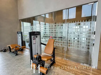 a waiting room with chairs and a wall of wine bottles at LUX 52 42 Deluxe Marina View Suite 3 in Dubai