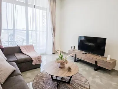 a living room with a couch and a tv at Majestic Retreat - 1BR Dubai in Dubai