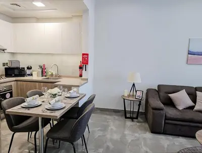a kitchen and a living room with a table and a couch at Majestic Retreat - 1BR Dubai in Dubai
