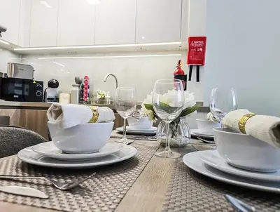 a table with plates and wine glasses on it at Southside Spacious & Sleek - 2BR in Dubai
