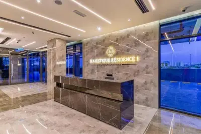 a lobby of a building with a sign on the wall at Studio Luxe Dubai South in Dubai