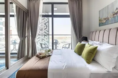 a bedroom with a large bed and a large window at Studio Luxe Dubai South in Dubai