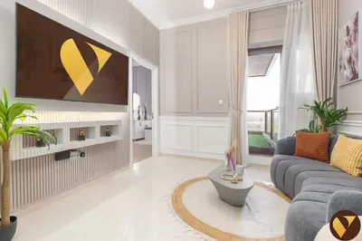 a living room with a couch and a tv on a wall at Vogue Sports City Elite near First Avenue Mall, One Bedroom Apartment with Balcony and Vibrant Community View, Access to all Amenities in Dubai