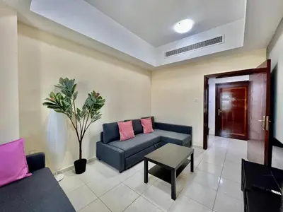 a living room with a blue couch and a table at Close to The World Trade Center and DIFC in Dubai