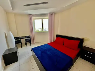 a bedroom with a red and blue bed and a table at Close to The World Trade Center and DIFC in Dubai