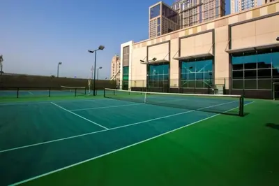 a tennis court in front of a building at Luxury 2BR Canal front & Burj Khalifa views- High Floor in Dubai