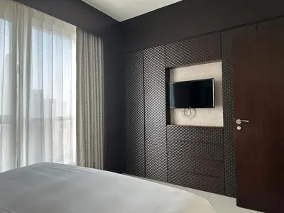 a bedroom with a bed and a tv on a wall at A&S Downtown Dubai in Dubai