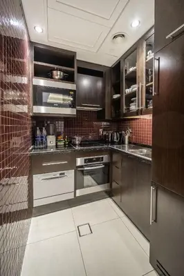 a kitchen with stainless steel appliances and brown cabinets at A&S Downtown Dubai in Dubai