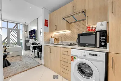 a kitchen with a washer and a washing machine at Luxury Palm Studio - Skyline Views - Rooftop Pool & Beach Access in Dubai