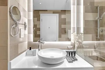 a bathroom with a white sink and a mirror at Luxury Palm Studio - Skyline Views - Rooftop Pool & Beach Access in Dubai