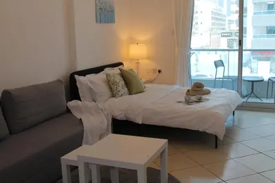a living room with a bed and a couch at Studio apartment walking distance to metro and beach in Marina in Dubai