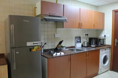 a kitchen with a stainless steel refrigerator and a dishwasher at Studio apartment walking distance to metro and beach in Marina in Dubai