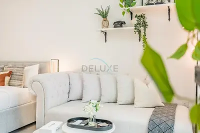 a white living room with a white couch at Just Steps Away from Circle Mall, Right Beside a Park, Near Restaurants, Conveniently Close to a Bus Stop, Lumina Vista Residences, Jumeirah Village Circle by Deluxe Holiday Homes in Dubai
