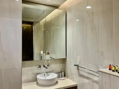 a white bathroom with a sink and a mirror at DAYF-PENZOR Upgraded Studio for 4 with Full Burj View in Dubai