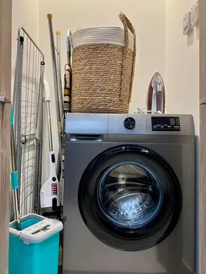 a washing machine in a laundry room with a basket at DAYF-PENZOR Upgraded Studio for 4 with Full Burj View in Dubai