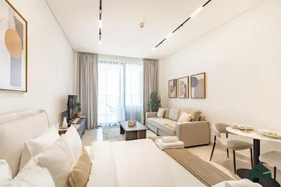 a living room with white furniture and a table at Luxury Studio with Canal View and Jacuzzi by BMS in Dubai