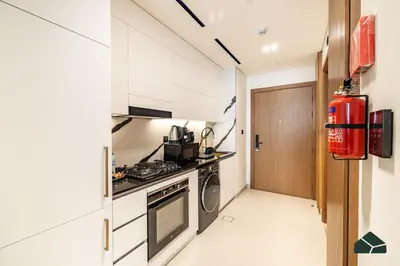 a small kitchen with a stove and a fire extinguisher at Luxury Studio with Canal View and Jacuzzi by BMS in Dubai