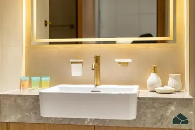 a bathroom sink with a gold faucet and a mirror at Luxury Studio with Canal View and Jacuzzi by BMS in Dubai