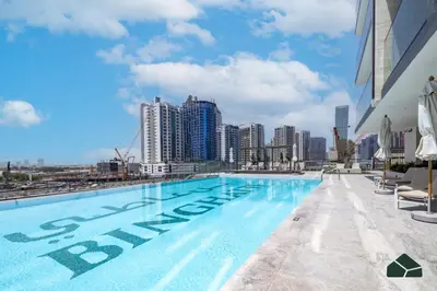 a swimming pool with a city skyline in the background at Luxury Studio with Canal View and Jacuzzi by BMS in Dubai