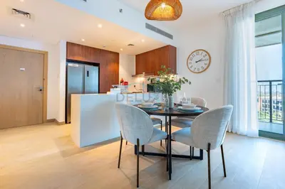 a kitchen and dining room with a table and chairs at Urban Beachside 2BR with a Glimpse of Burj Khalifa, Near Jumeirah Beaches, Short Drive to Mercato Mall, La Sirene Building 4, Jumeirah by Deluxe Holiday Homes in Dubai
