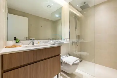 a bathroom with a sink and a toilet and a mirror at Urban Beachside 2BR with a Glimpse of Burj Khalifa, Near Jumeirah Beaches, Short Drive to Mercato Mall, La Sirene Building 4, Jumeirah by Deluxe Holiday Homes in Dubai