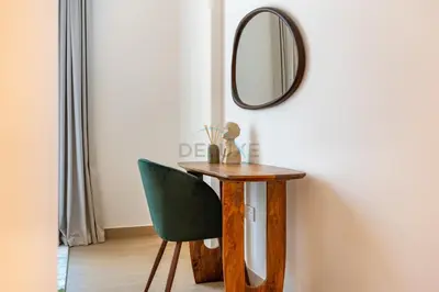 a table with a green chair and a mirror at Urban Beachside 2BR with a Glimpse of Burj Khalifa, Near Jumeirah Beaches, Short Drive to Mercato Mall, La Sirene Building 4, Jumeirah by Deluxe Holiday Homes in Dubai