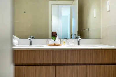 a bathroom with two sinks and a large mirror at Urban Beachside 2BR with a Glimpse of Burj Khalifa, Near Jumeirah Beaches, Short Drive to Mercato Mall, La Sirene Building 4, Jumeirah by Deluxe Holiday Homes in Dubai