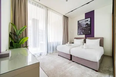a hotel room with two beds and a tv at SettlerHomes - Elite 2BR With Private Jacuzzi Oasis in Dubai
