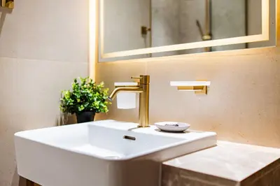 a white sink with a gold faucet in a bathroom at SettlerHomes - Elite 2BR With Private Jacuzzi Oasis in Dubai