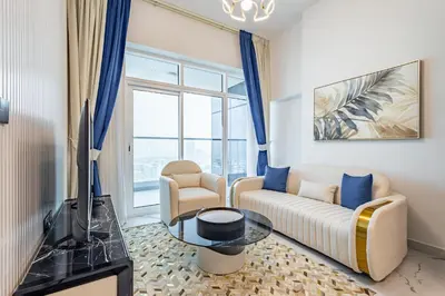 a living room with a couch and a tv at Superhost- 1BR Near Miracle Garden, Pool and Gym, Balcony Arjan in Dubai