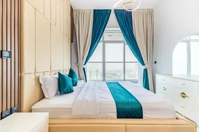 a bedroom with a bed with a large window at Superhost- 1BR Near Miracle Garden, Pool and Gym, Balcony Arjan in Dubai