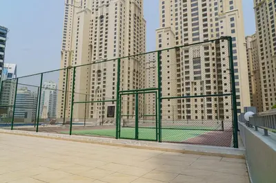 a batting cage in a city with tall buildings at Modern 2BR Apartment at JBR in Dubai