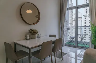 a dining room with a table and chairs and a mirror at Modern 2BR Apartment at JBR in Dubai